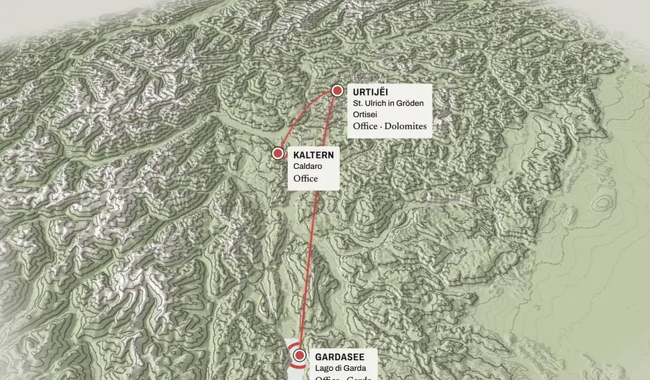 Still: rising above the peaks; lines connect the office in Urtijëi to Kaltern / Caldaro and Lake Garda.